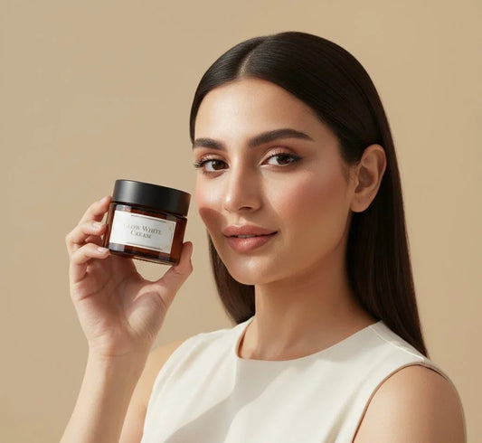 Woman holding Glow White Cream from AamBazar, skincare product against beige background
